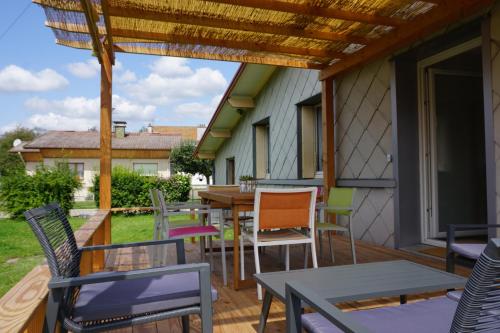 a patio with tables and chairs on a deck at La maison et l'étang - grand terrain privé in Vagney