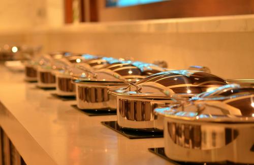 a row of silver pots lined up on a counter at The Umrao in New Delhi