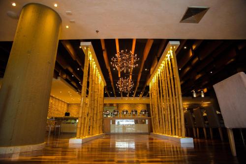 una hall con colonne e lampadario pendente in un edificio di Rosa Bela Hotel & Convention Center a Puerto Ordaz