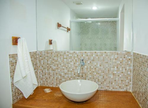 uma casa de banho com um lavatório branco num balcão de madeira em Jeri Village Hotel em Jericoacoara