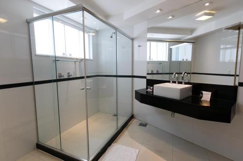 y baño con ducha acristalada y lavamanos. en Casablanca Center Hotel, en Petrópolis