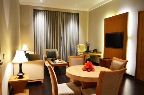 a hotel room with a table and chairs and a television at The Umrao in New Delhi