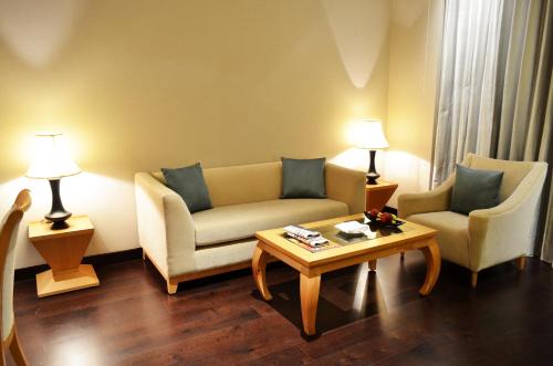 a living room with two chairs and a coffee table at The Umrao in New Delhi