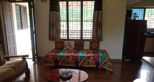 a living room with a bed and a coffee table at Shree Homestay in Manipala