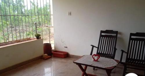 a room with two chairs and a table and a window at Shree Homestay in Manipala