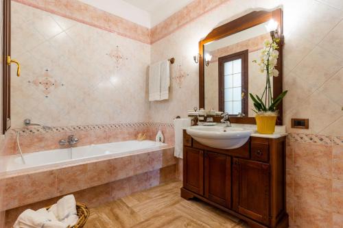 y baño con bañera, lavabo, bañera y espejo. en The Rosa's Luxury House, en Alezio