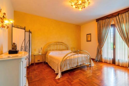 1 dormitorio con 1 cama y suelo de madera en The Rosa's Luxury House, en Alezio