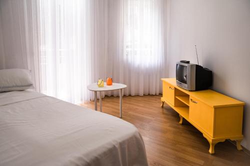 um quarto com uma cama e uma televisão numa cómoda em Artament Prishtina em Pristina