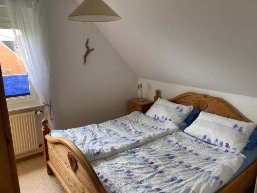 una camera con letto e testata in legno di Ferienwohnungen Brasse a Neuharlingersiel