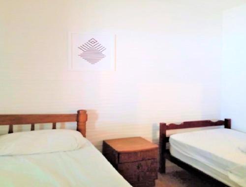 een kamer met 2 aparte bedden en een tafel bij Casa a uma quadra da praia in Maresias