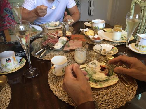 a group of people sitting at a table eating food at Champagne House - Elegance, Luxury and Charm in Condom