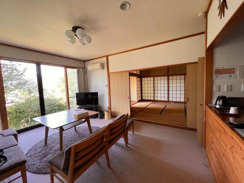 a living room with a table and chairs in a room at Yufuin Hoshinosato in Yufuin