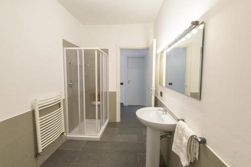 Baño blanco con lavabo y espejo en Gli Zerbi, en Gavi