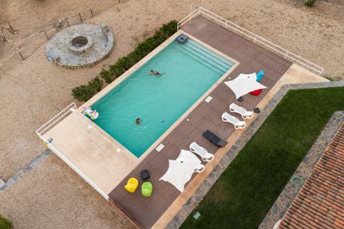 an overhead view of a swimming pool with two people in it at Monte Ribeira de Mures in Évora