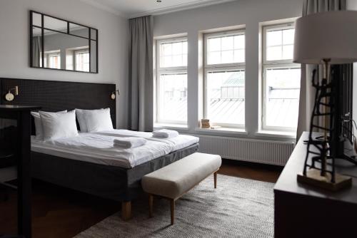 a bedroom with a bed and a chair and windows at Bob W Koti Katajanokka in Helsinki