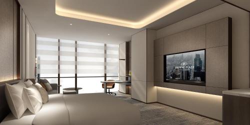 a bedroom with a bed and a tv on a wall at Crowne Plaza Zhengzhou High Tech Zone by IHG in Zhengzhou