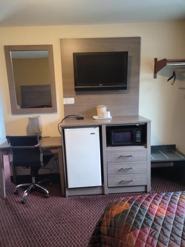 a hotel room with a desk with a tv and a desk sidx sidx sidx sidx at Seneca Clipper Inn in Watkins Glen