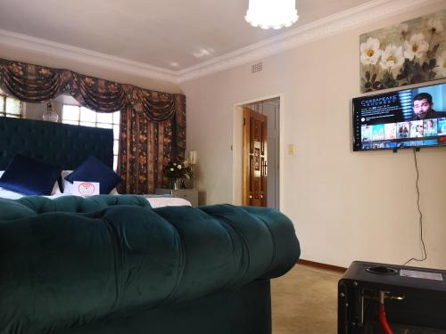 a living room with a couch and a flat screen tv at CHIC Guest House & Solar system accommodations in Germiston