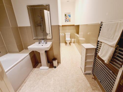 ein Badezimmer mit Waschbecken, Badewanne und Toilette in der Unterkunft Seas the Day Beachfront Apartment Ramsgate - Sleeps 4 in Ramsgate
