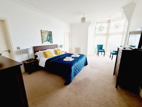 a bedroom with a bed and two chairs and a television at Seas the Day Beachfront Apartment Ramsgate - Sleeps 4 in Ramsgate