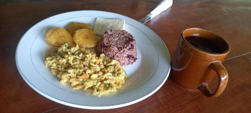 a plate of food on a table with a cup of coffee at Finca Magdalena Eco Lodge in Balgue