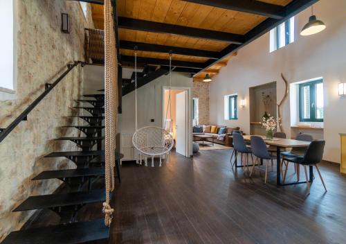 een woonkamer met een trap en een tafel en stoelen bij Corfu Pigeon Nest in Corfu-stad