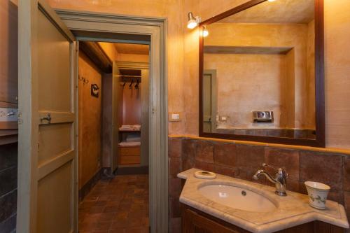 La salle de bains est pourvue d'un lavabo et d'un miroir. dans l'établissement Dimora Migliori, à Viagrande