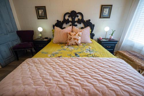 a bedroom with a large bed with pink pillows at Chateau Royale, Pet Friendly, On Bayou, Downtown! in New Iberia