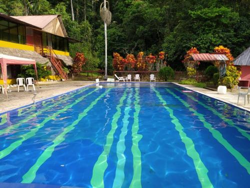 a large swimming pool with blue and green water at Grand Selva Lodge & Tours in Tena