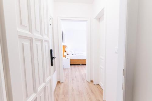 a white hallway with a bed in a bedroom at Villa Lilith Smart in Fertőrákos