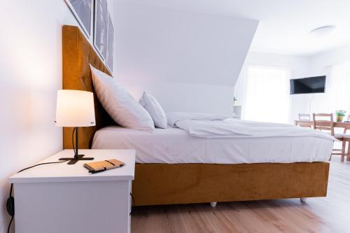 a bedroom with a bed and a table with a lamp at Villa Lilith Smart in Fertőrákos