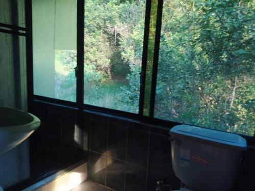a bathroom with a window and a toilet and a sink at Grand Selva Lodge & Tours in Tena