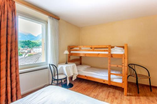 1 Schlafzimmer mit 2 Etagenbetten und einem Fenster in der Unterkunft Rustico by Al Giardinetto in Biasca