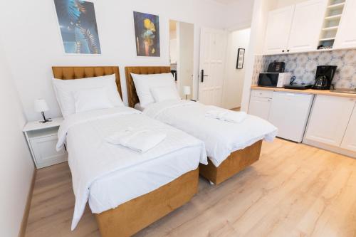 two beds in a room with a kitchen at Villa Lilith Smart in Fertőrákos