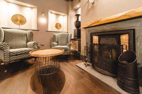 a living room with a table and a fireplace at Borrowdale Gates Hotel in Keswick