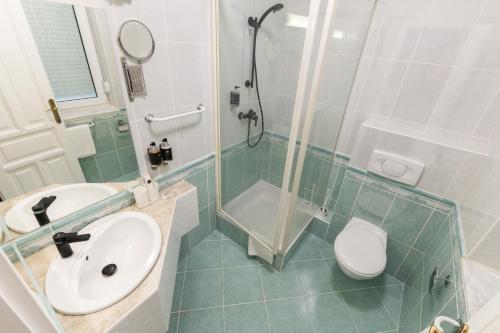 a bathroom with a sink and a shower and a toilet at Villa Lilith Smart in Fertőrákos