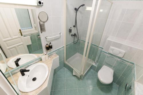 a bathroom with a sink and a shower and a toilet at Villa Lilith Smart in Fertőrákos