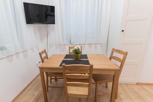 a dining room table with chairs and a tv at Villa Lilith Smart in Fertőrákos