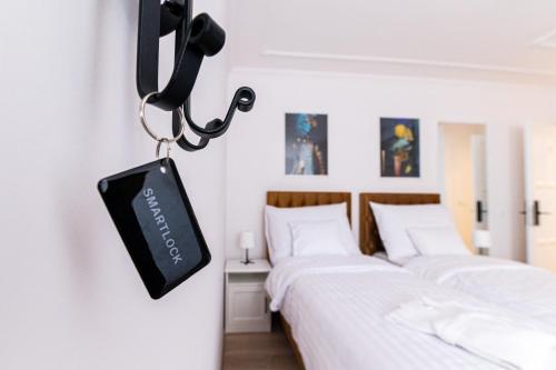 two beds in a room with a tv on the wall at Villa Lilith Smart in Fertőrákos
