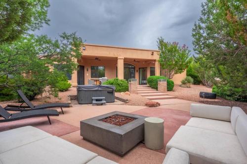 a patio with couches and a fire pit in front of a building at Amazing Luxury Home with Hot Tub & Views in Sedona
