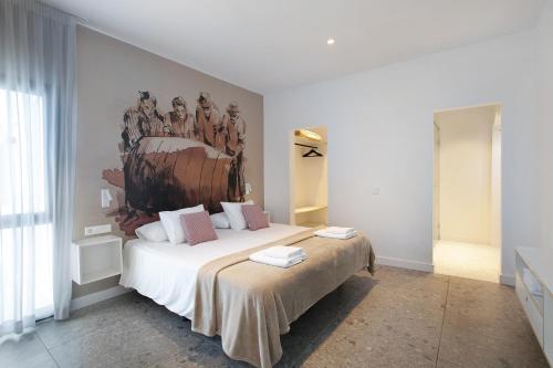 1 dormitorio con 1 cama con una pintura en la pared en Linaje del Pago Castellana, en Tacoronte