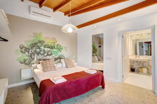a bedroom with a large bed with a painting on the wall at Linaje del Pago Malvasia in Sauzal