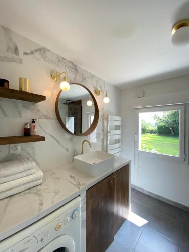 a bathroom with a sink and a washing machine at La Maison des Vacances, à deux pas de la mer. in Hautot-sur-Mer