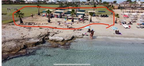 an aerial view of a beach with people on the sand at Arabel open space in San Lorenzo