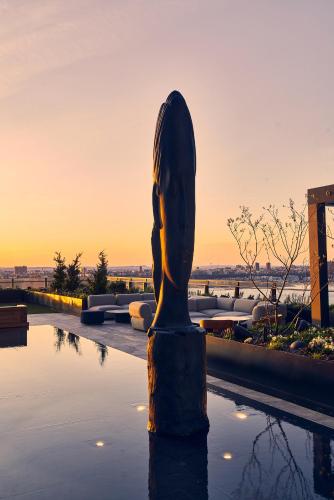 a statue in a pool with the sunset in the background at Equinox Hotel New York in New York