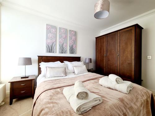 a bedroom with a large bed with towels on it at Shore Thing Beachfront Apartment Ramsgate - Sleeps 4 in Ramsgate