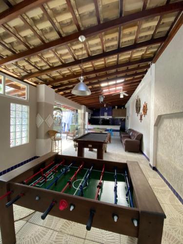 a living room with a pool table in the middle at Pousada Floresta in Bombinhas