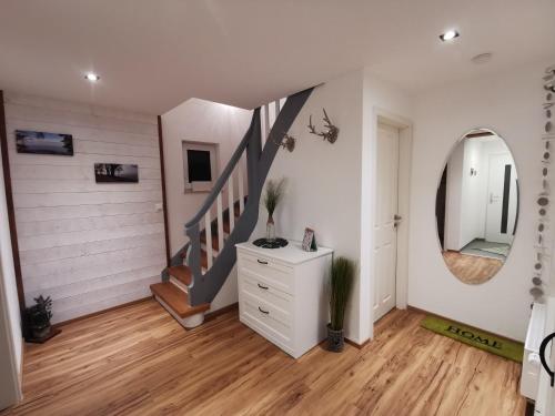 a room with a staircase and a dresser and a mirror at Ferienwohnung Chiemseeliebe in Chieming
