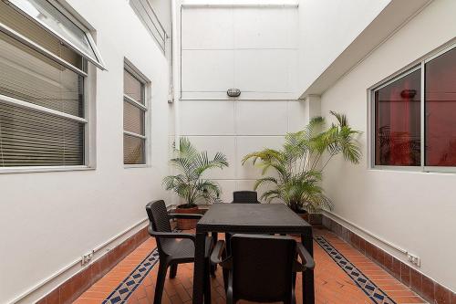 una mesa y sillas en una habitación con plantas en Hotel Casa Palermo, en Medellín