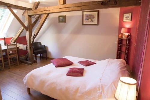 um quarto com uma cama branca com almofadas vermelhas em Gite ferme XVIII 4 chambres /8 personnes Chimay em Momignies